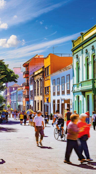 Line of colourful buildings with pedestrians walking on street