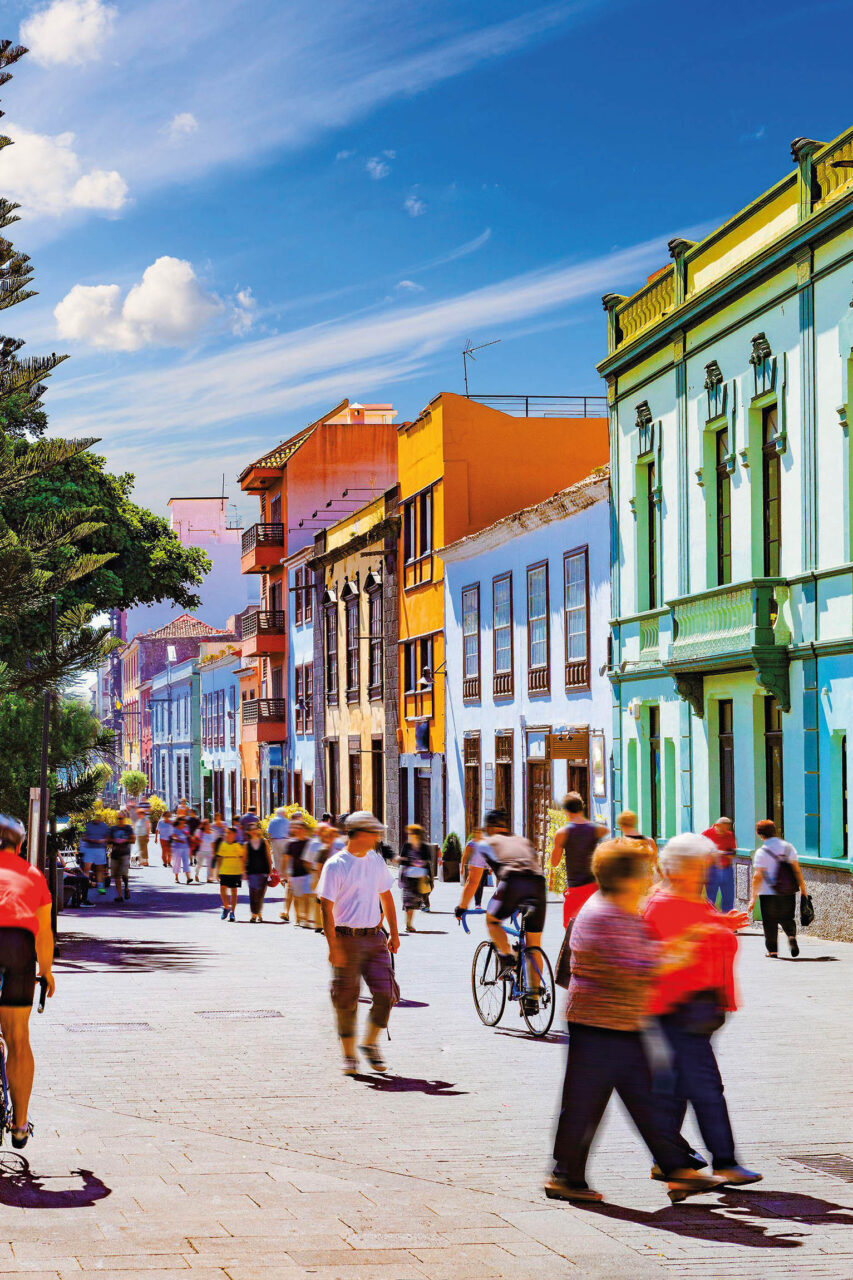 Line of colourful buildings with pedestrians walking on street