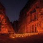 Al-Khaznah, or the Treasury in Petra, Jordan, at night time. The entrance is lit up by candles