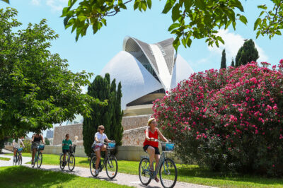 Tourists cycle past modern art building in Valencia